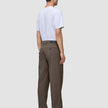 En person set bagfra, iført en hvid T-shirt og Atelier Pants Relaxed Dark Beige i kraftig, brudt twill.