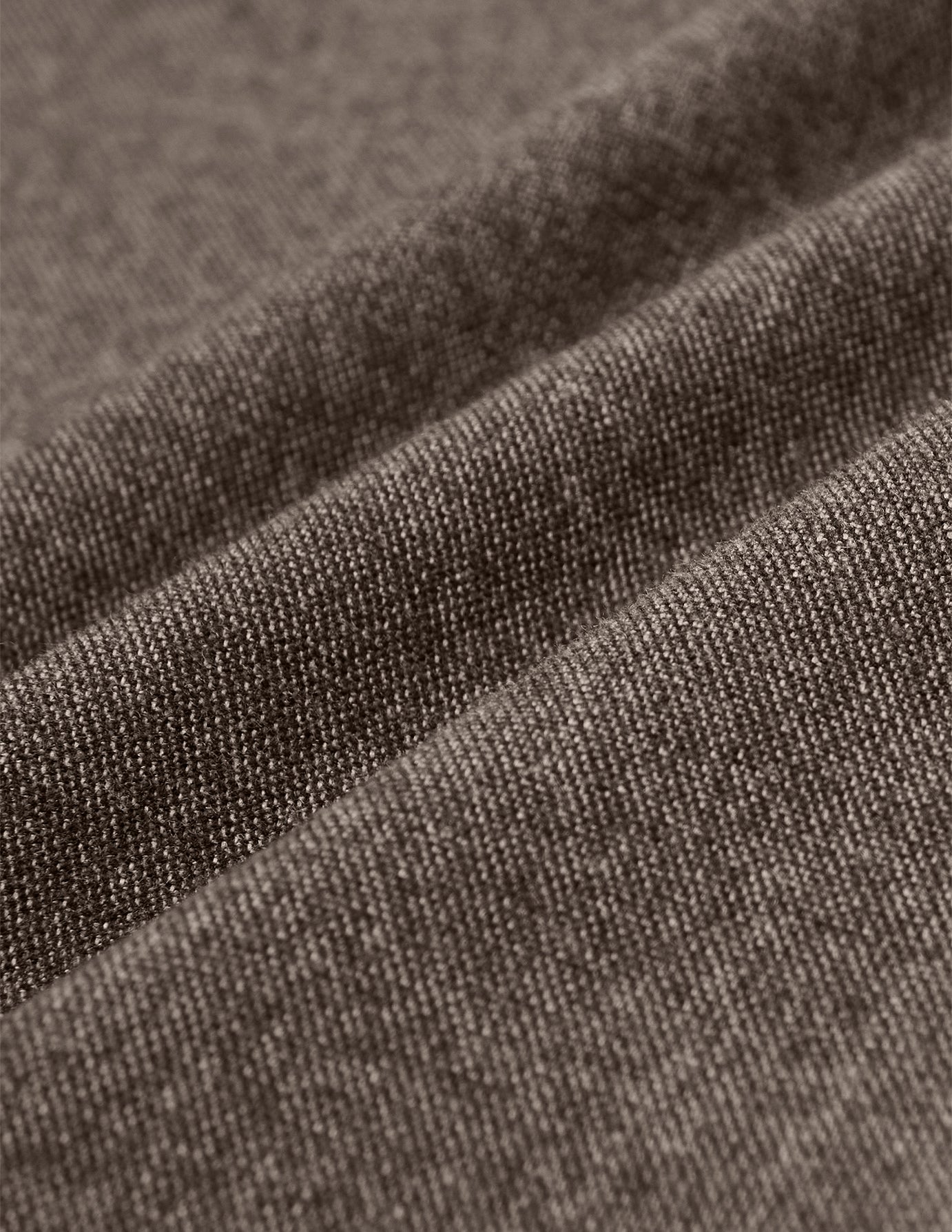 Nærbillede af Atelier Pants Relaxed Dark Beige i brunt, kraftigt twill-stof med synlig vævning og bløde folder.