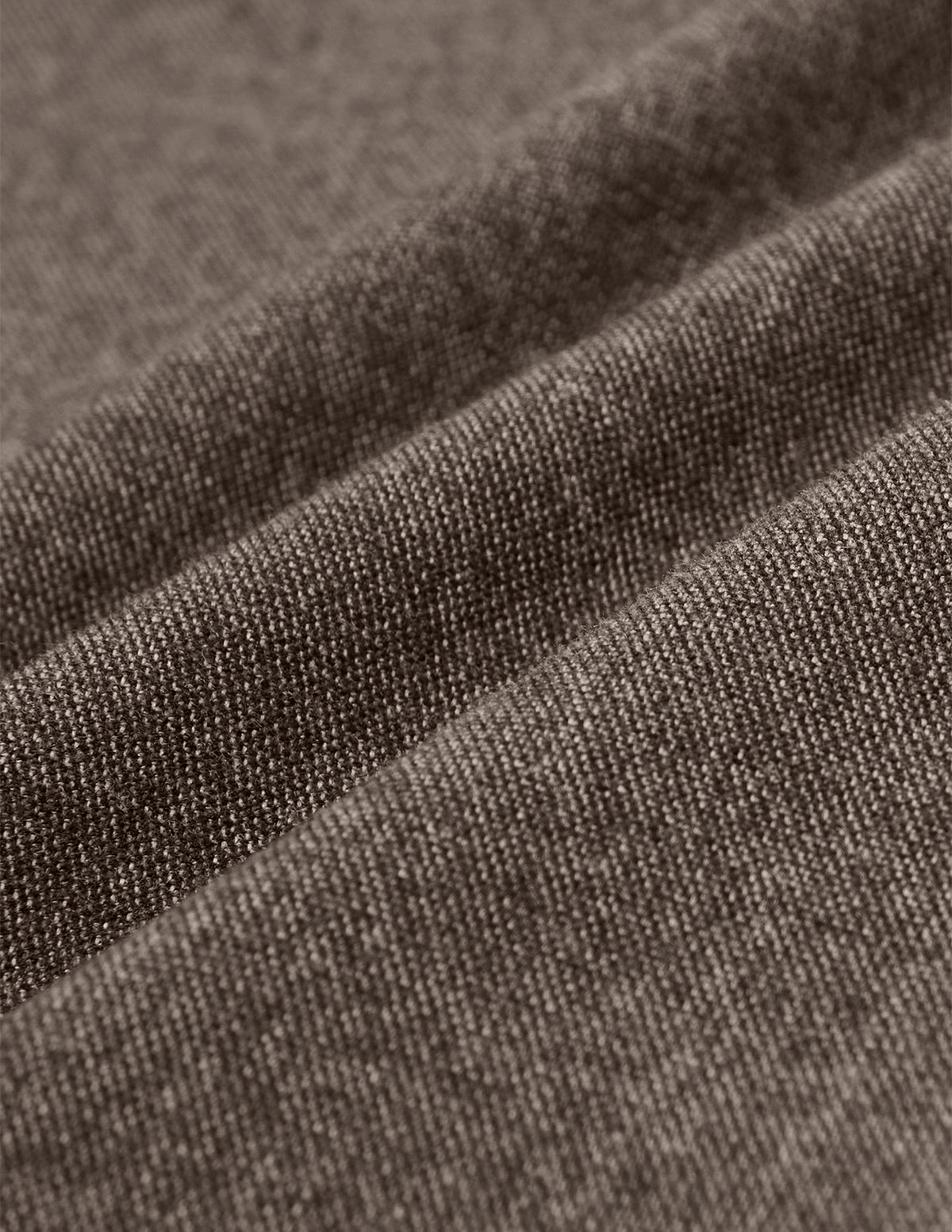 Nærbillede af Atelier Pants Relaxed Dark Beige i brunt, kraftigt twill-stof med synlig vævning og bløde folder.