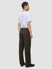 En person set bagfra, iført en hvid T-shirt og mørkebrune Atelier Pants Relaxed – et eksempel på dansk design.