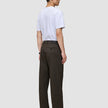 En person set bagfra, iført en hvid T-shirt og mørkebrune Atelier Pants Relaxed – et eksempel på dansk design.