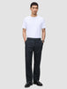 En mand i en hvid T-shirt, sorte loafers og Atelier Pants Relaxed Dark Navy, der er indbegrebet af afslappet dansk design.