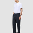 En mand i en hvid T-shirt og Atelier Pants Relaxed Dark Navy, stylet i minimalistisk dansk design.