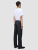 En mand set bagfra, iført en hvid T-shirt og et par Atelier Pants Relaxed i mørk marineblå.