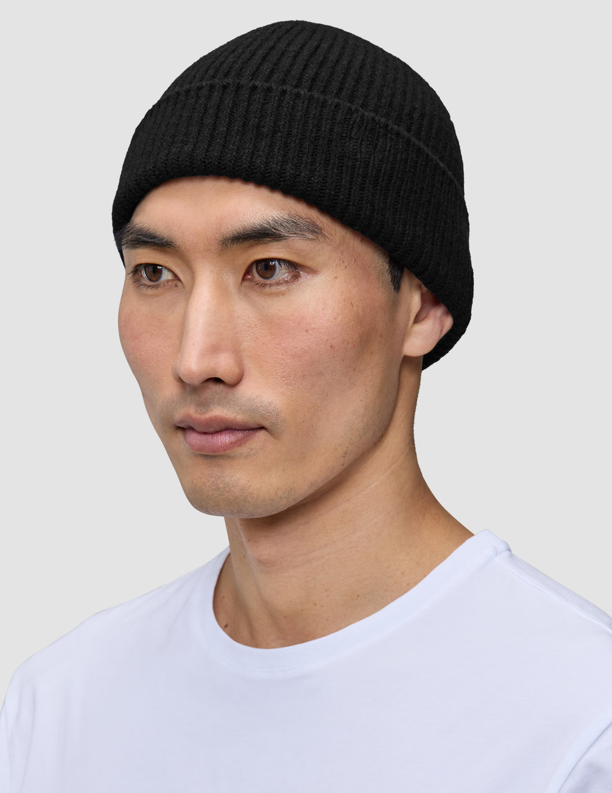 En mand iført en håndstrikket, sort, ribbet hue Beanie Black.