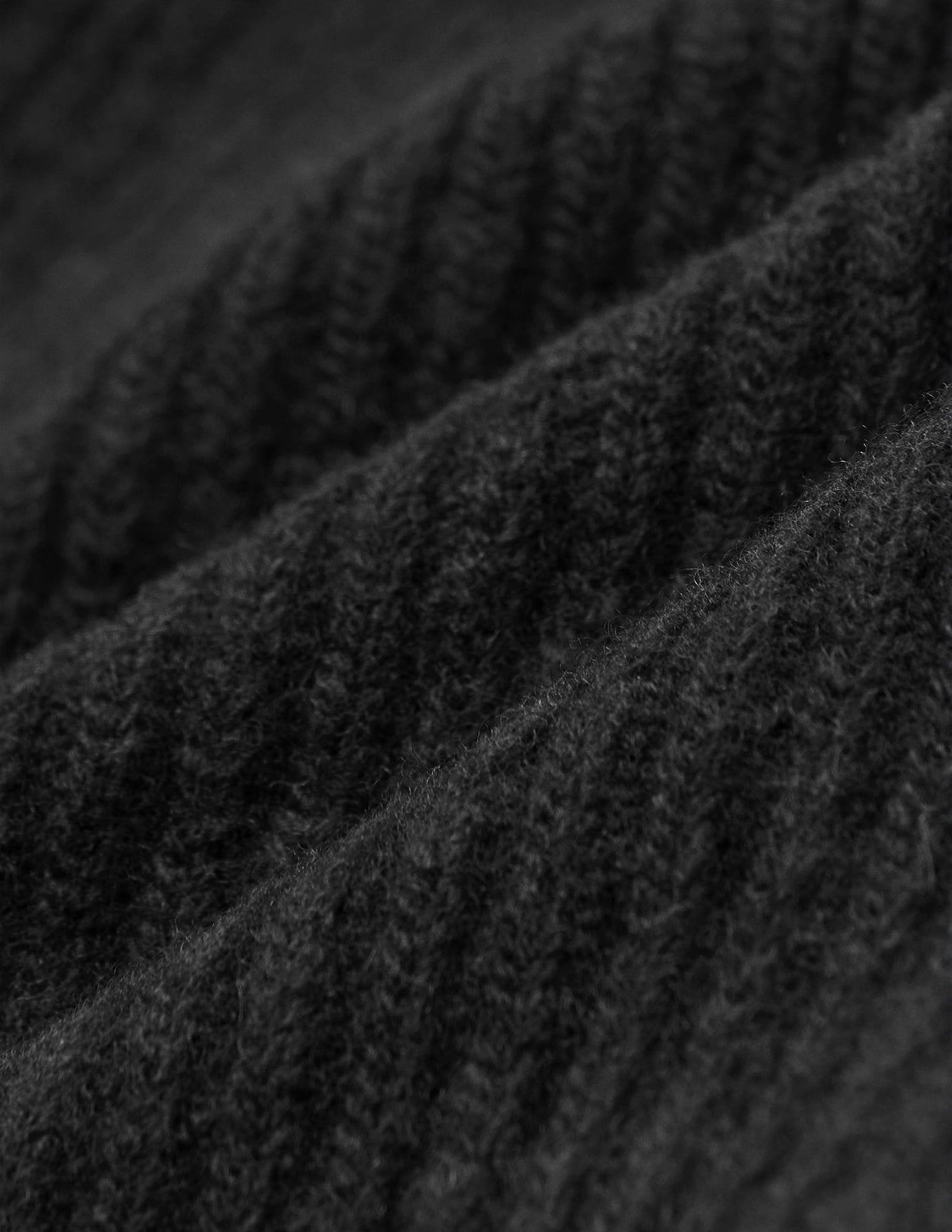 Nærbillede af sort, ribstrikket stof på en håndstrikket Beanie Black.