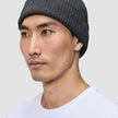 En person, der bærer en mørkegrå, ribbet hue med dansk design.