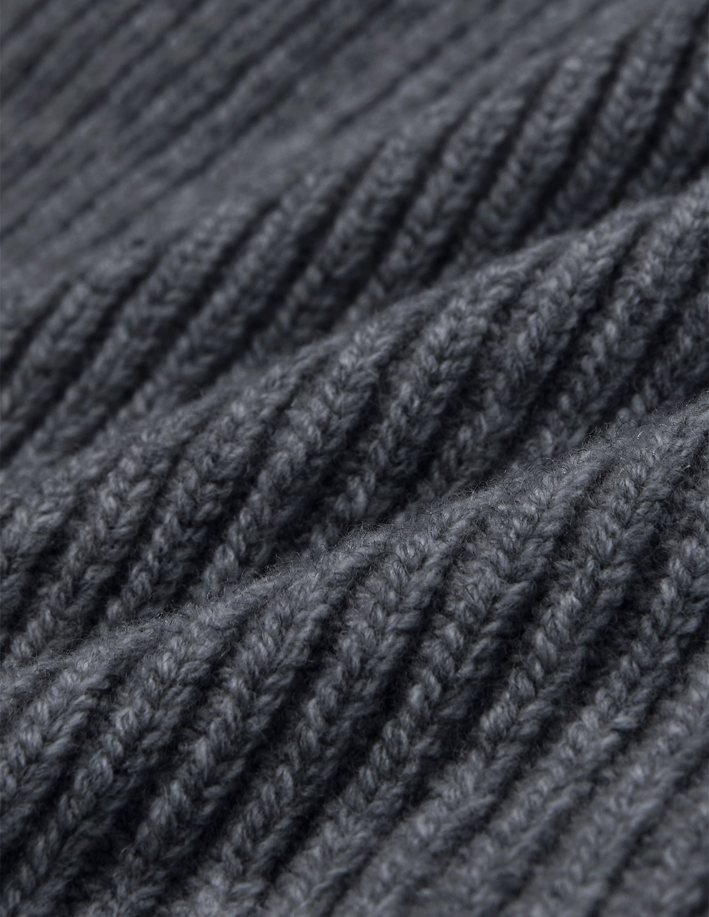 Nærbillede af en Beanie Dark Grey i mørkegrå merinould i ribstrik.