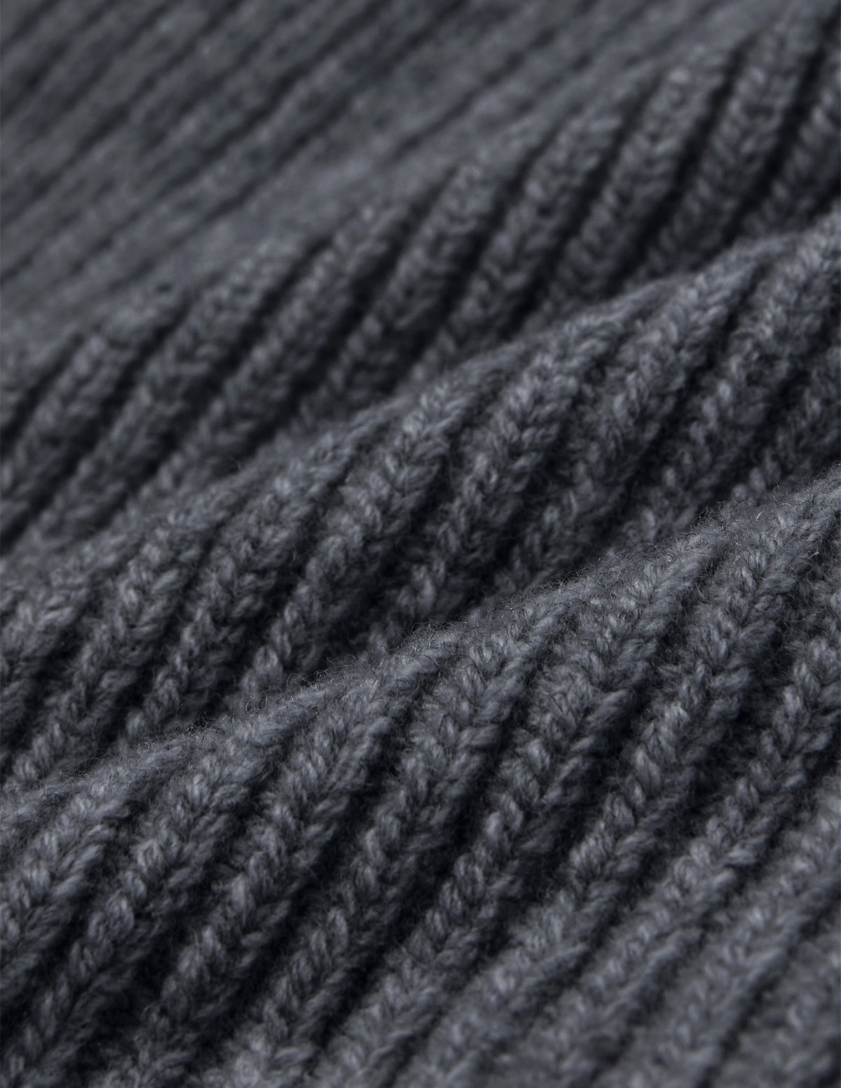 Nærbillede af en Beanie Dark Grey i mørkegrå merinould i ribstrik.