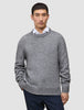 En person, der har en tyk, blød uldstrikket sweater med rund hals i farven Glacier Grey på over en hvid skjorte med krave.