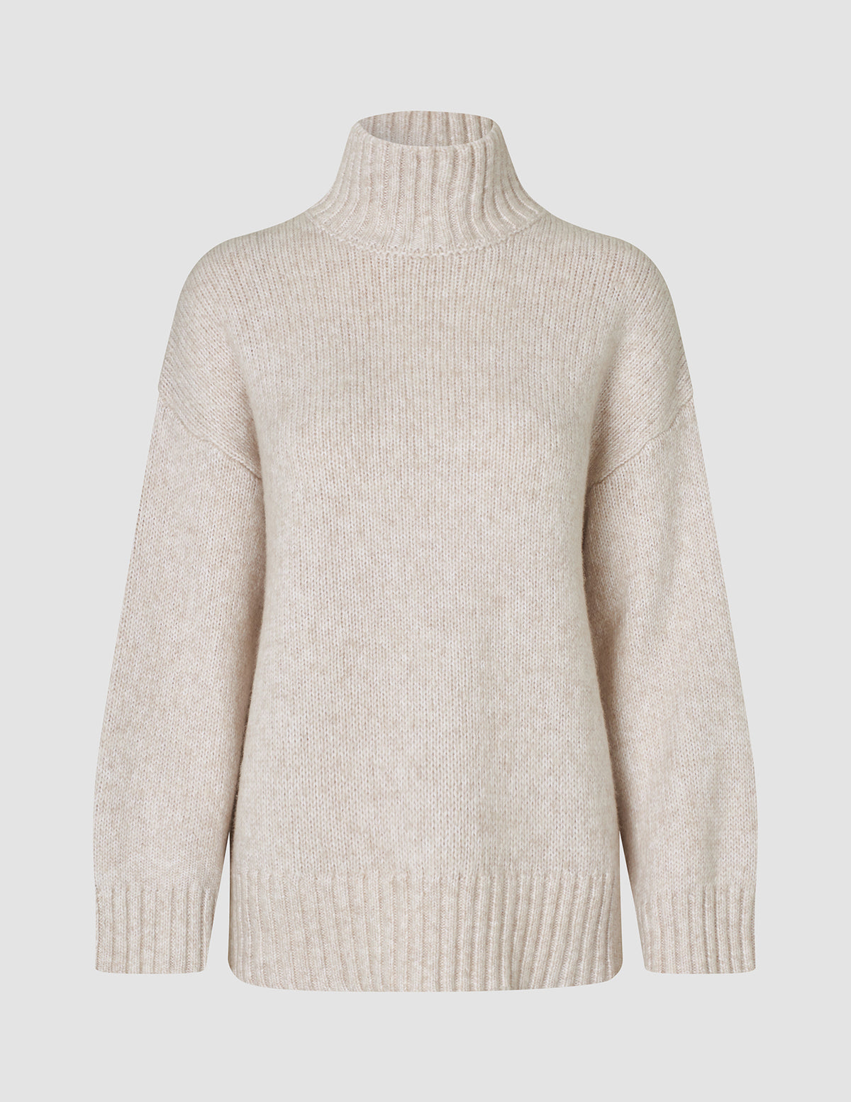 Damestrikket rullekravebluse i tyk, blød uld i farven Sugar Melange – et beige, groft ribstrikket design med rullekrave.
