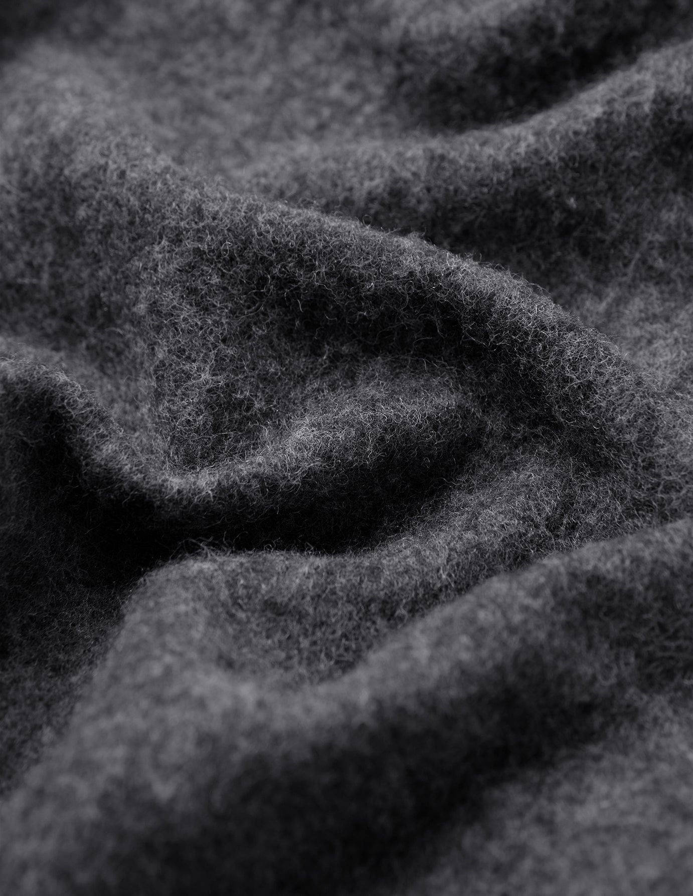 Nærbillede af det bløde, mørkegrå Double Layer Wool Overshirt Regular Dark Grey-stof med folder.