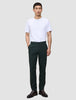 En mand iført en hvid T-shirt, Ease Pants Regular Northern Pine og brune læderstøvler.