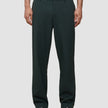 Ease Pants Relaxed Fit Northern Pine mørkegrønne bukser kombineret med mørkebrune loafers.