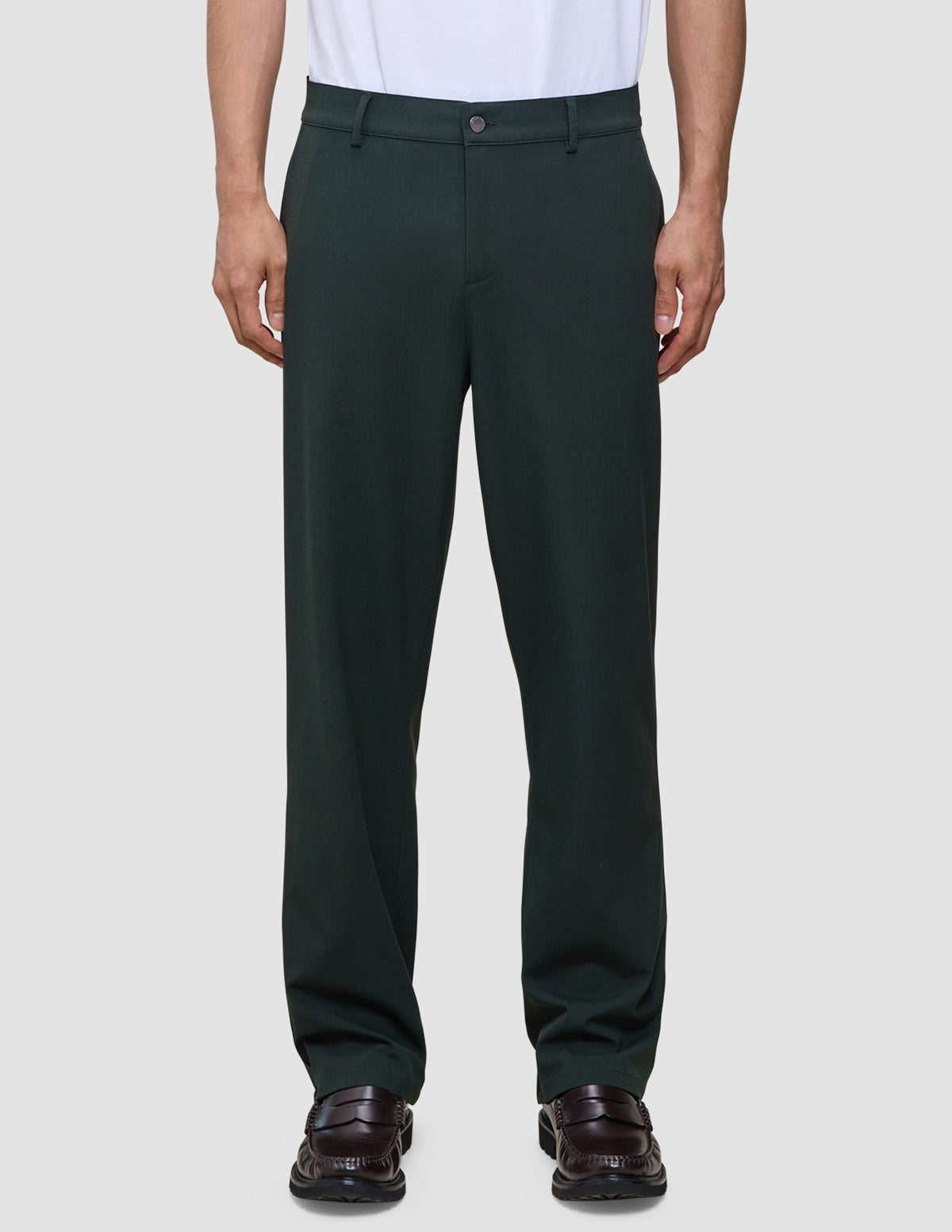 Ease Pants Relaxed Fit Northern Pine mørkegrønne bukser kombineret med mørkebrune loafers.