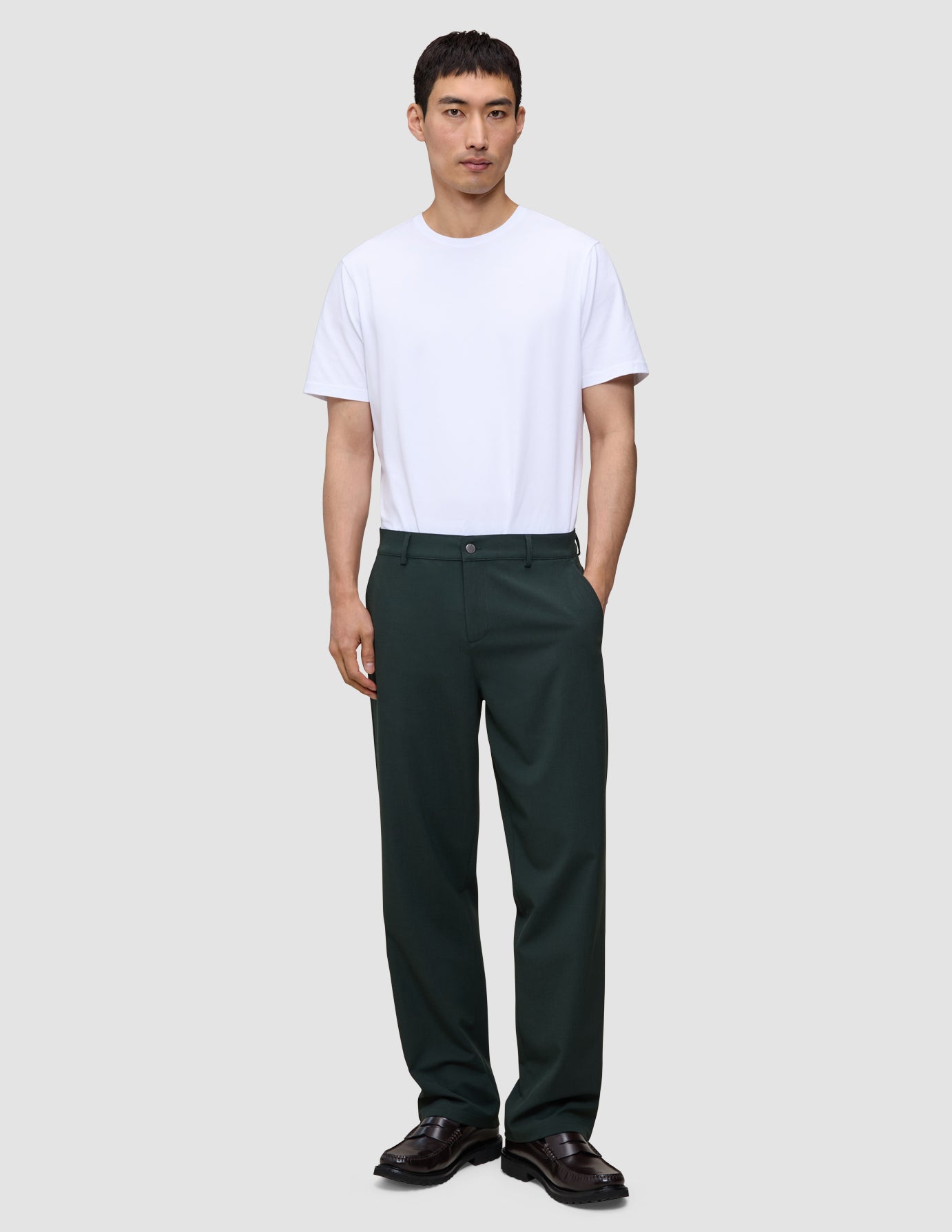 En mand iført en hvid T-shirt og Ease Pants Relaxed Fit Northern Pine med en afslappet pasform.