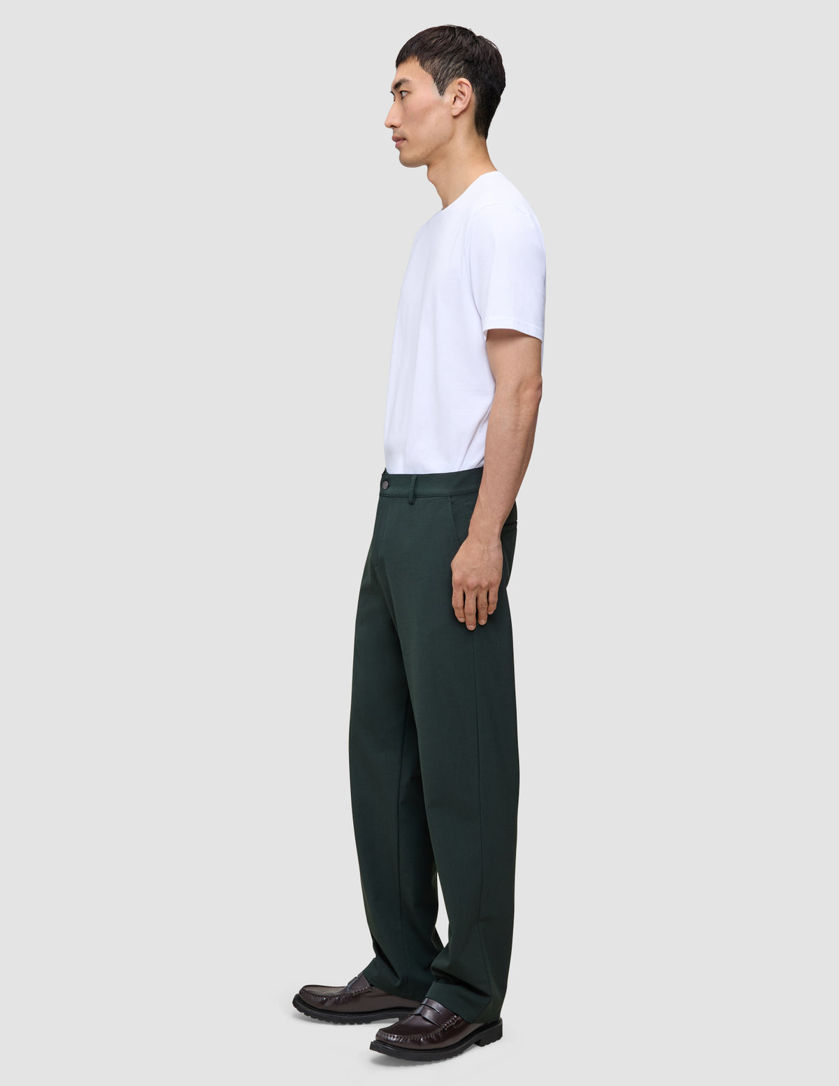 En mand i en hvid T-shirt og Northern Pine Ease-bukser i afslappet pasform med 360°-stretch.