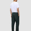 En mand set bagfra, iført en hvid T-shirt og mørkegrønne Ease Pants Relaxed Fit Northern Pine i en afslappet pasform.