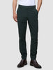 En person iført Ease Pants Slim Northern Pine med 360°-stretch og brune læderstøvler.
