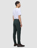En mand i en hvid T-shirt og Ease Pants Slim Northern Pine står set i profil iført brune læderstøvler.
