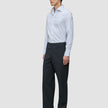 Mand iført en Elevated Shirt Slim Classic med blå striber og mørkegrå bukser.