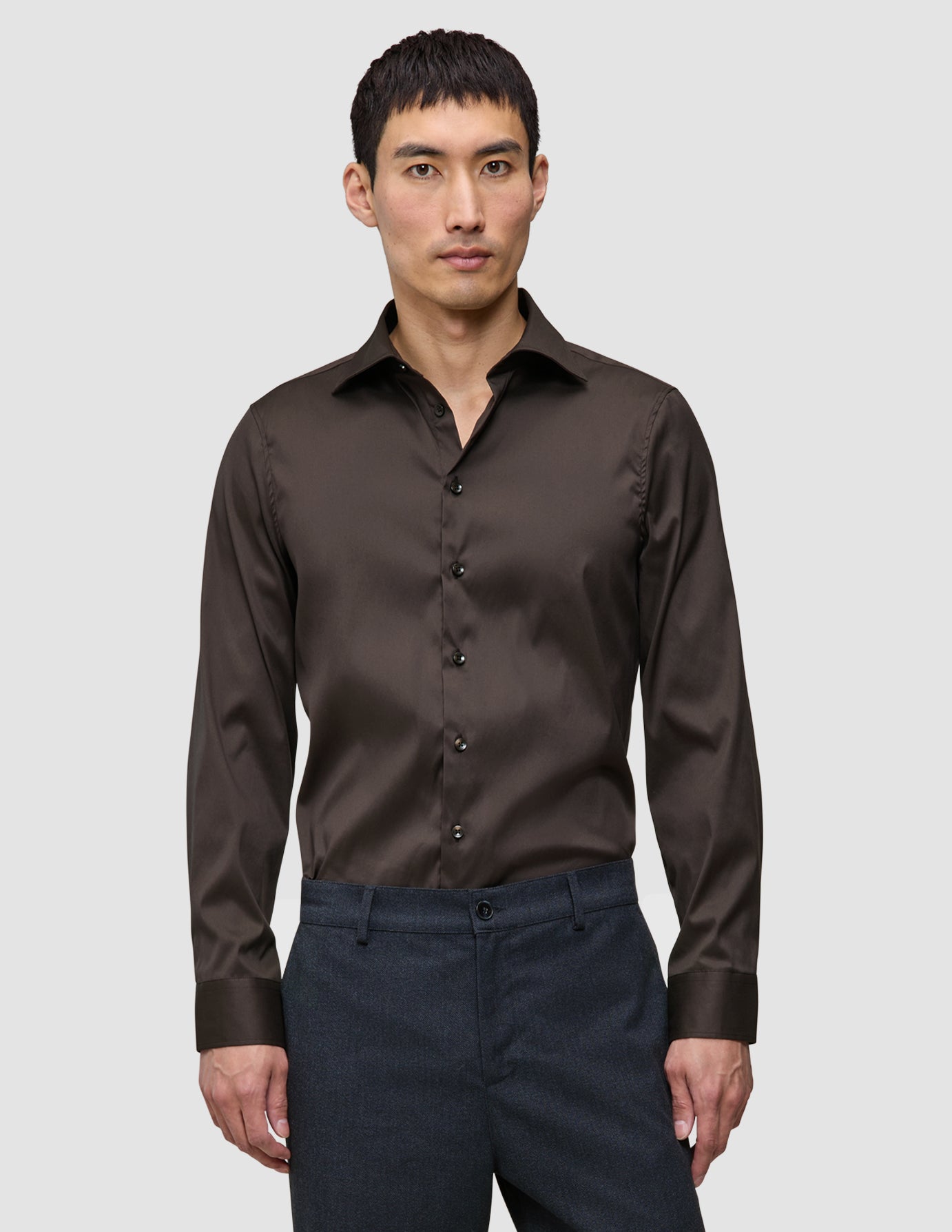 En mand iført en Elevated Shirt Slim Dark Brown i slim fit, mørkebrun Pima-bomuld med button-down-krave.