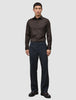 En mand har en mørkebrun Elevated Shirt Slim i Pima-bomuld på sammen med mørke bukser og fine sko.