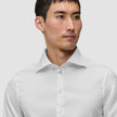 Mand iført en Elevated Shirt White Slim, en hvid skjorte med knapper og spredt krave.