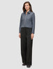 Kvinde iført en Essential Short Zip Jacket i mørkegrå melange og sorte bukser med brede ben.