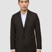 En mand iført en mørkebrun Motion Blazer Regular Cognac over en hvid skjorte med knapper.