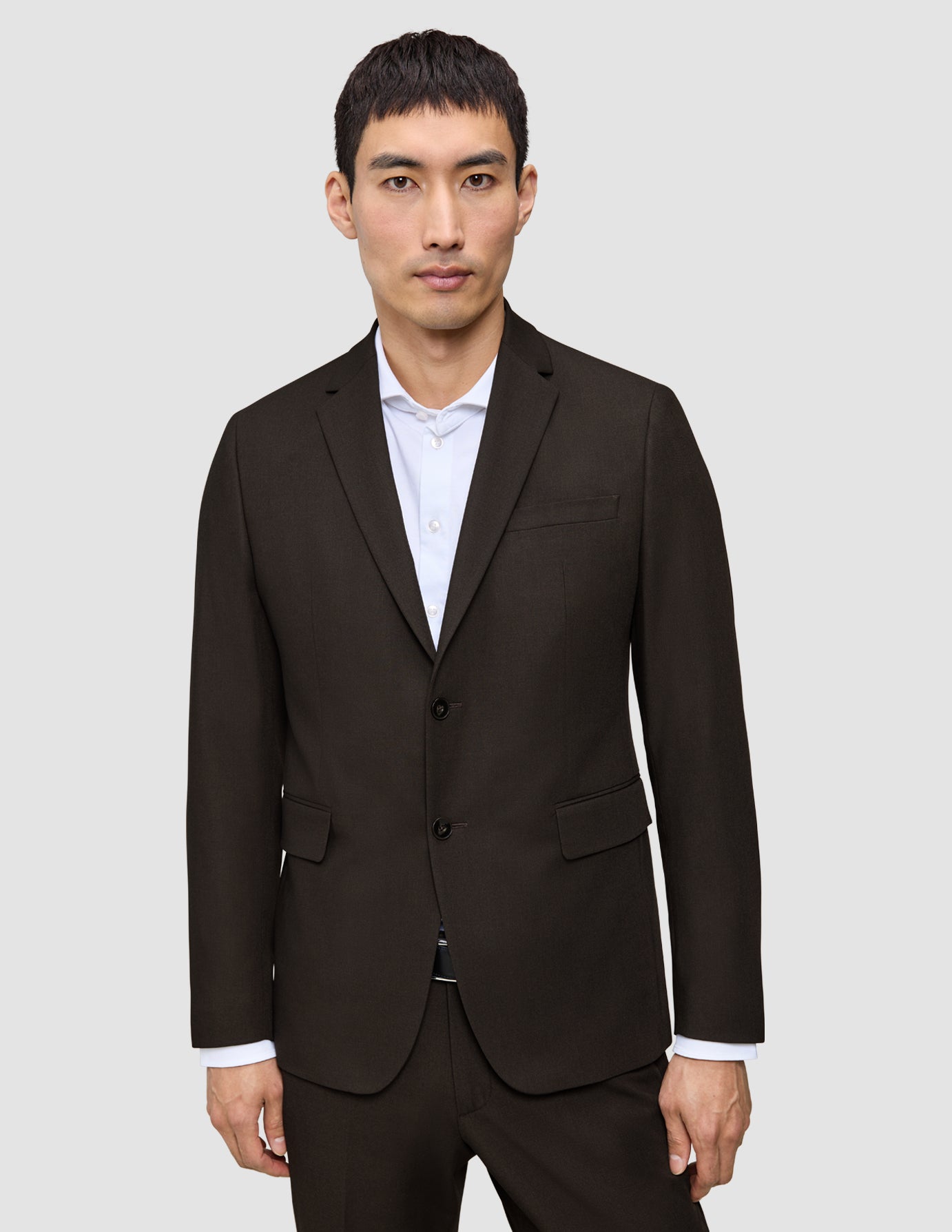 En mand iført en mørkebrun Motion Blazer Regular Cognac over en hvid skjorte med knapper.