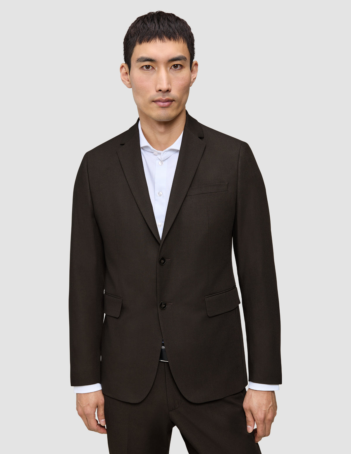 En mand iført en mørkebrun Motion Blazer Regular Cognac over en hvid skjorte med knapper.