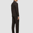 En mand i en brun Motion Blazer Regular Cognac og sorte dressko, set bagfra.