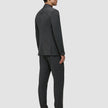 En mand iført en Motion Blazer Regular i farven Pepper Grey og mørke loafers, set bagfra.