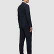 En mand set bagfra, iført en Motion Blazer Slim Midnight Blue-jakke og -bukser samt loafers.