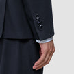 Nærbillede af et ærme fra en Motion Blazer Slim i farven Midnight Blue med fire manchetknapper og en stribet skjorte, der kan ses ved håndleddet.