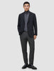 En mand iført en sort blazer, en grå rullekravebluse, Motion Suit-bukser i Regular-pasform i farven Pepper Grey og sorte loafers.