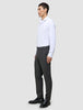 En mand i en hvid skjorte og Motion Suit-bukser i Regular Pepper Grey står set i profil og er indbegrebet af det rene danske design.