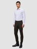 En mand iført en hvid skjorte med knapper, Motion Suit Pants Slim Cognac og sorte støvler.