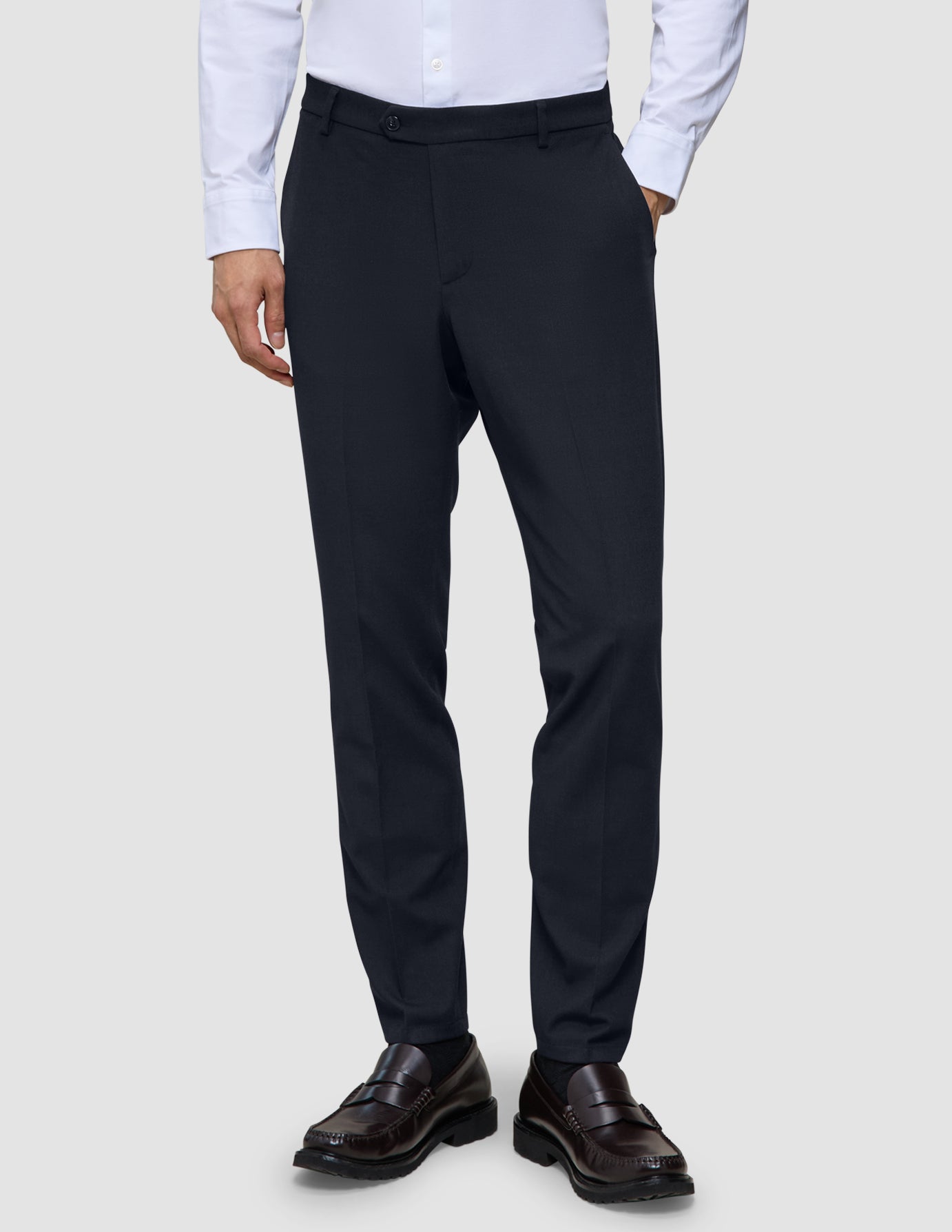 Slim-fit Motion Suit-bukser i farven Slim Midnight Blue med 360°-stretch, kombineret med en lys skjorte og mørke loafers.
