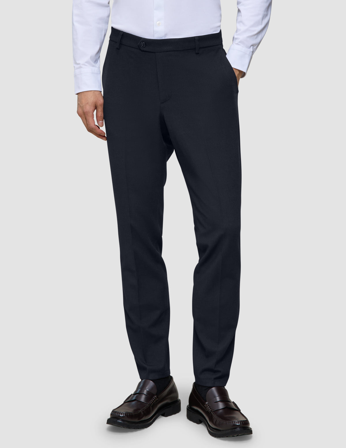 Slim-fit Motion Suit-bukser i farven Slim Midnight Blue med 360°-stretch, kombineret med en lys skjorte og mørke loafers.