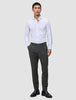 En mand i en hvid skjorte med knapper og et par Motion Suit-bukser i farven Slim Pepper Grey samt sorte loafers.