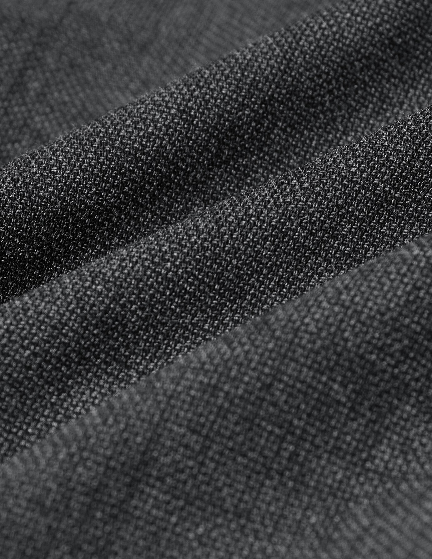 Nærbillede af det grå, 360°-elastiske stof med en struktureret, strikagtig vævning på Motion Suit Pants Slim Pepper Grey.
