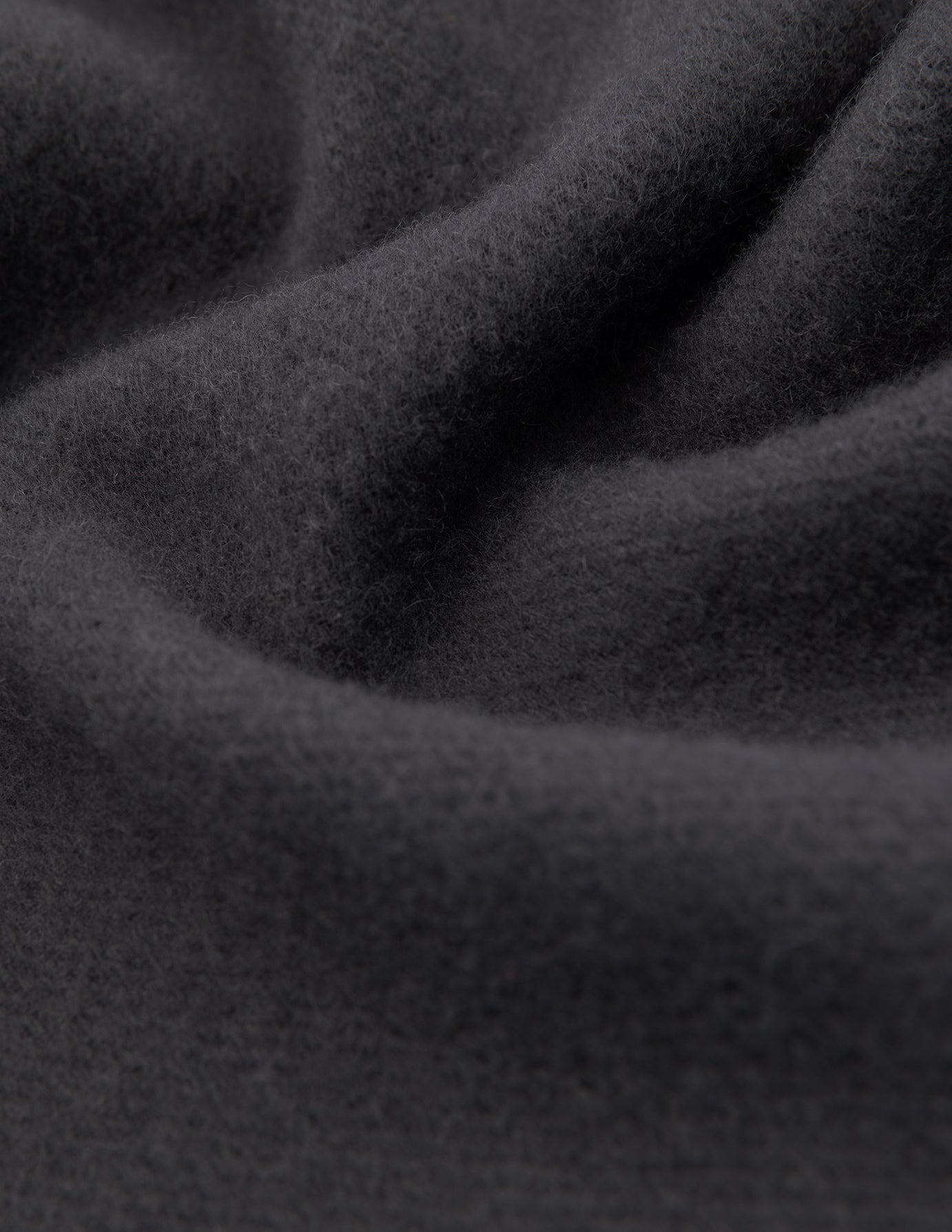 Nærbillede af et foldet tørklæde i farven Charcoal Grey i dansk design.