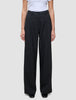 Person iført en hvid T-shirt og et par Serene Pants Wide Black med læg foran.