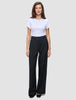 En kvinde iført en hvid T-shirt og et par Serene Pants Wide Black med brede ben.