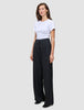 Kvinde iført en hvid T-shirt og sorte Serene Pants Wide Black med bredt ben og høj talje.