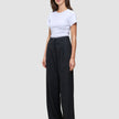 Kvinde iført en hvid T-shirt og sorte Serene Pants Wide Black med bredt ben og høj talje.