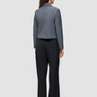 Bagfra-billede af en person iført en grå blazer og sorte Serene Pants Wide Black.