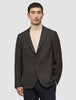 En mand iført en mørkebrun, slim-fit Timeless Wool Blazer med tern over en beige rullekravebluse.